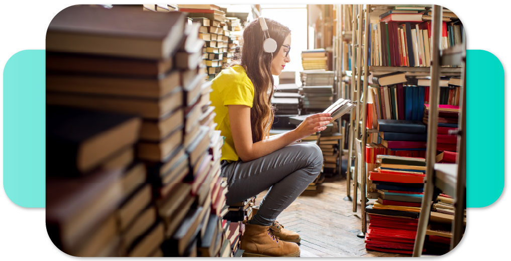 Mergina bibliotekoje labai susidomėjusi skaito knygą.